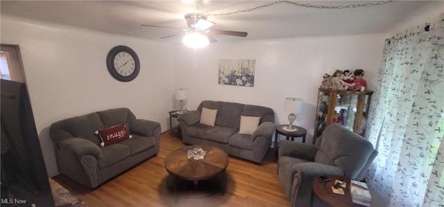 living room with a ceiling fan and wood finished floors