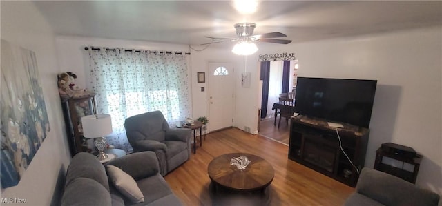 living area with a ceiling fan and wood finished floors