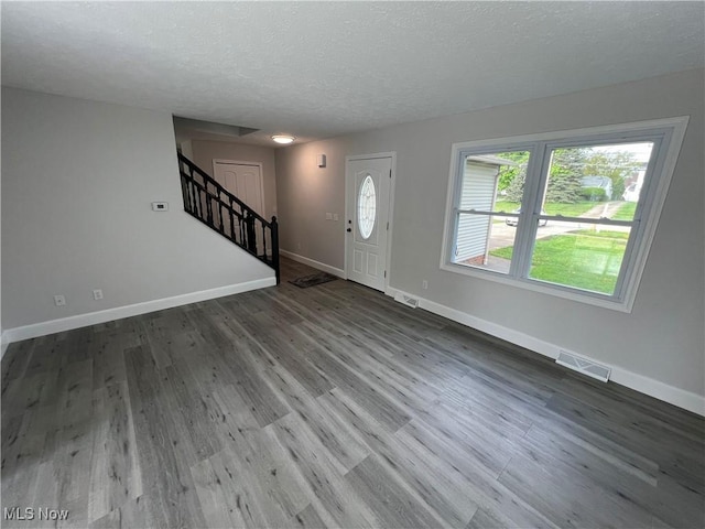 1279 Lander Rd, Mayfield Heights, OH 44124 - interior space featuring a textured ceiling, baseboards, visible vents, stairs, and wood finished floors