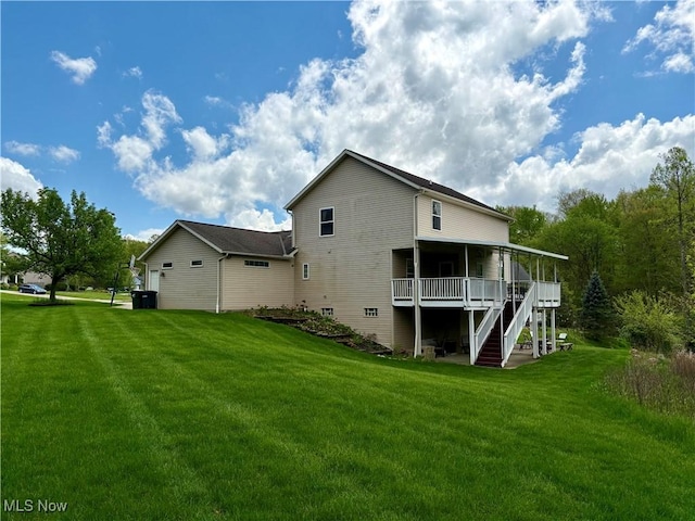 back of property featuring a sunroom, a lawn, and stairs