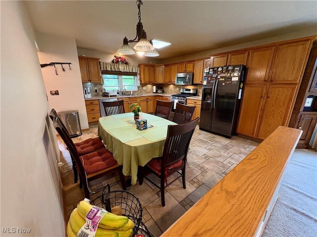 kitchen featuring a sink, brown cabinets, light countertops, and appliances with stainless steel finishes
