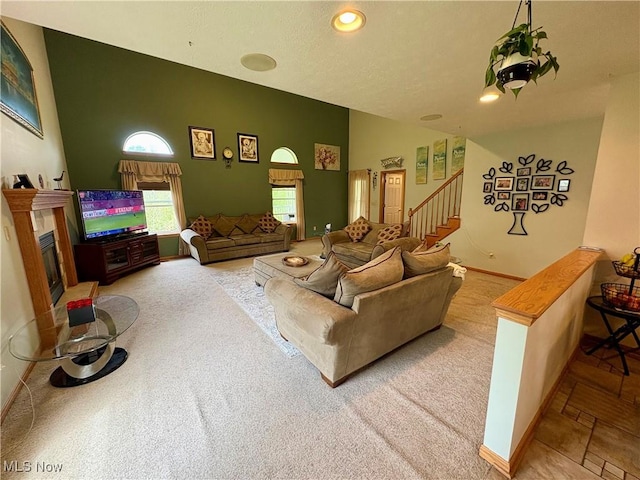 carpeted living room featuring stairs, baseboards, a glass covered fireplace, and recessed lighting