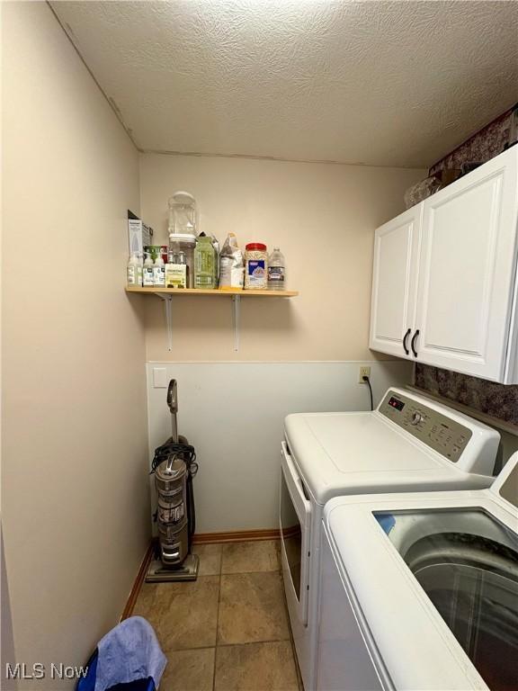 laundry room with baseboards, independent washer and dryer, and cabinet space