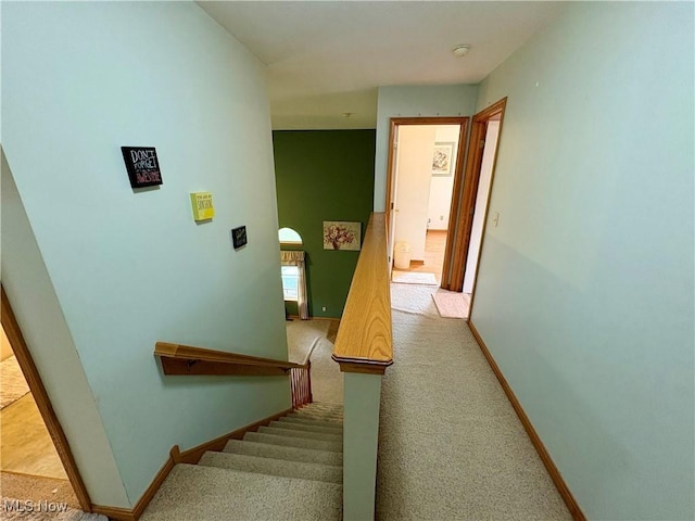 staircase with baseboards and carpet floors