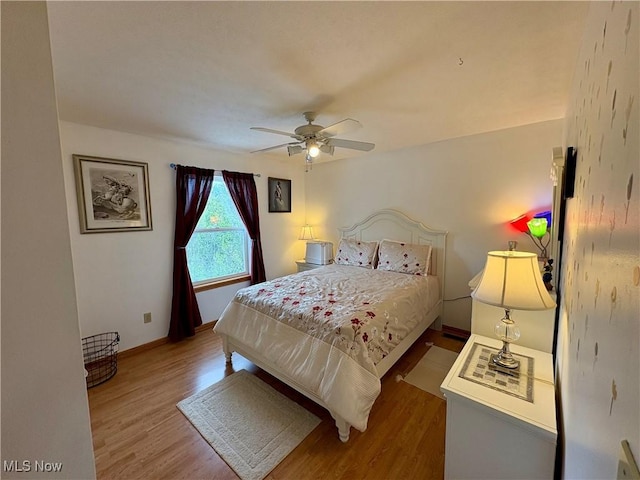 bedroom featuring wood finished floors, baseboards, and ceiling fan