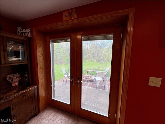 doorway to outside with light colored carpet and french doors