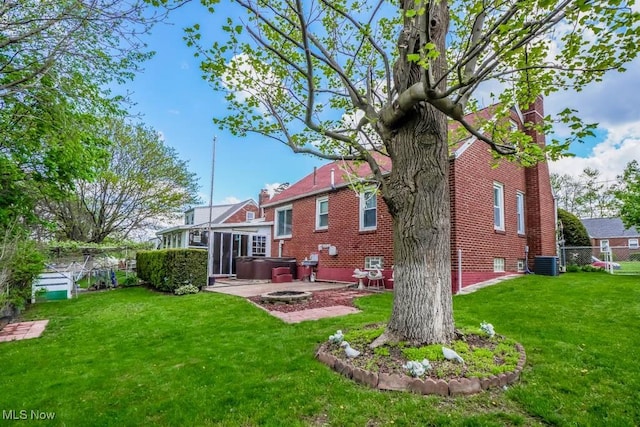 back of house with a jacuzzi, central air condition unit, a fenced backyard, a yard, and a patio area