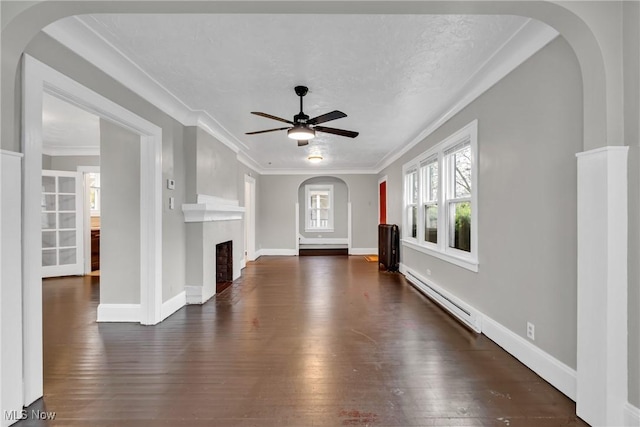 unfurnished living room featuring a fireplace, dark wood finished floors, ceiling fan, a baseboard radiator, and ornamental molding