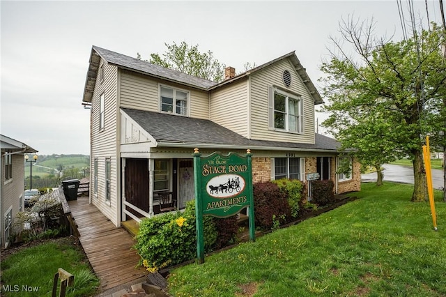 4991 Walnut St, Sugarcreek, OH 44681 - traditional-style house featuring a front lawn, brick siding, roof with shingles, and a chimney