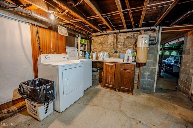 4991 Walnut St, Sugarcreek, OH 44681 - clothes washing area featuring washer and dryer, concrete block wall, and cabinet space