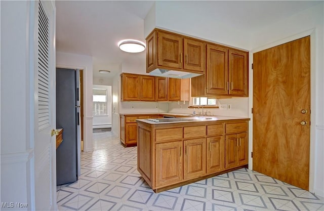 4840 W 228th St, Fairview Park, OH 44126 - kitchen with freestanding refrigerator, a peninsula, brown cabinets, a sink, and light flooring