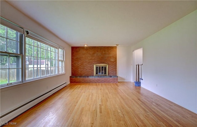 4840 W 228th St, Fairview Park, OH 44126 - unfurnished living room featuring a baseboard radiator, light wood-style floors, and a fireplace
