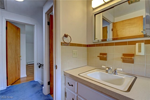 4840 W 228th St, Fairview Park, OH 44126 - bathroom featuring a baseboard heating unit, vanity, and decorative backsplash