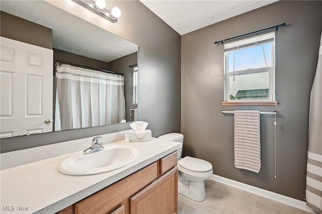 bathroom with toilet, a shower with curtain, vanity, a textured ceiling, and baseboards
