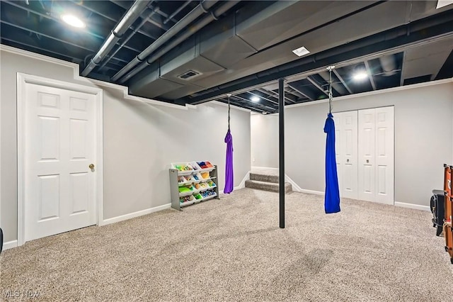 finished below grade area with carpet, visible vents, and baseboards