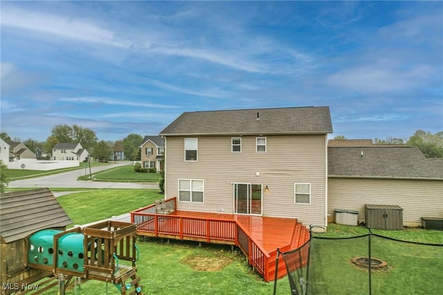 back of house with central air condition unit, a deck, and a lawn