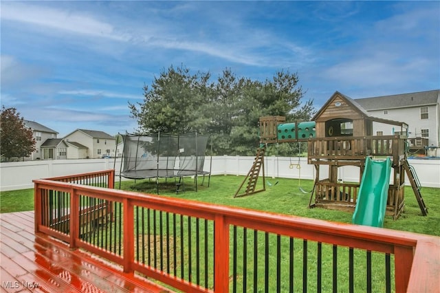 deck featuring a trampoline, a residential view, a yard, a fenced backyard, and a playground