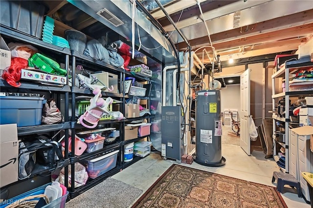 unfinished below grade area with water heater, heating unit, and visible vents