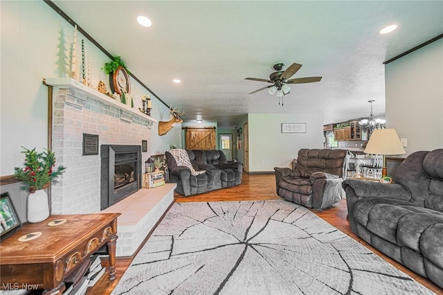 4661 Sugar Grove Rd, Cambridge, OH 43725 - living area featuring ceiling fan with notable chandelier, wood finished floors, visible vents, recessed lighting, and a brick fireplace