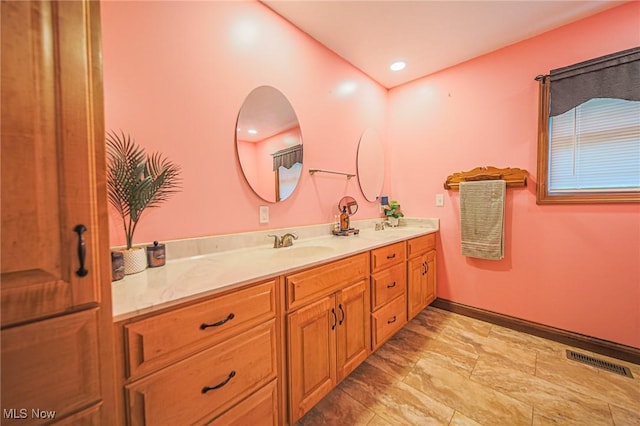 4661 Sugar Grove Rd, Cambridge, OH 43725 - bathroom featuring a sink, double vanity, baseboards, and visible vents