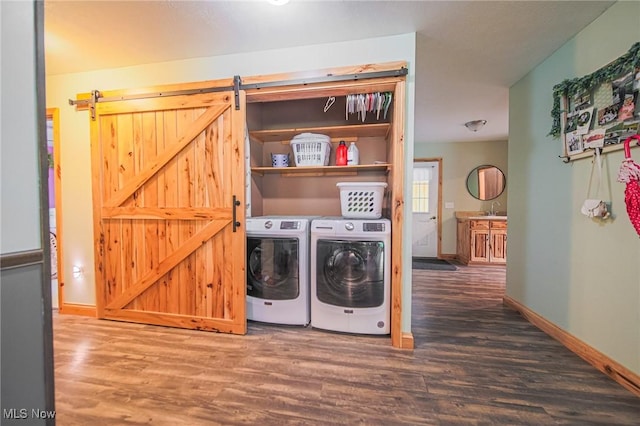 4661 Sugar Grove Rd, Cambridge, OH 43725 - clothes washing area with wood finished floors, laundry area, a barn door, washer and dryer, and baseboards