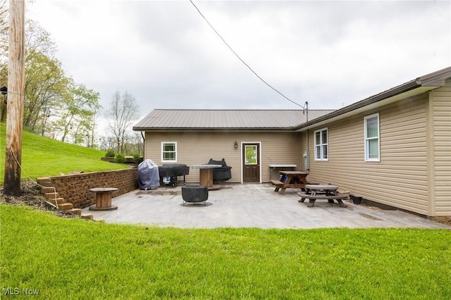 4661 Sugar Grove Rd, Cambridge, OH 43725 - back of property featuring metal roof, a patio area, a fire pit, and a lawn