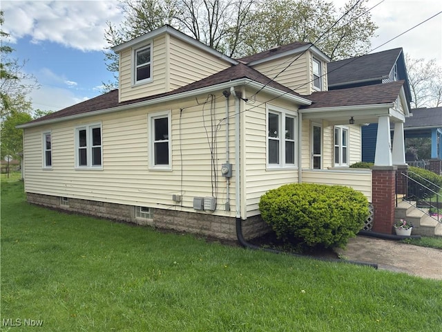 131 Blake St, Elyria, OH 44035 - view of home's exterior with covered porch, roof with shingles, and a lawn