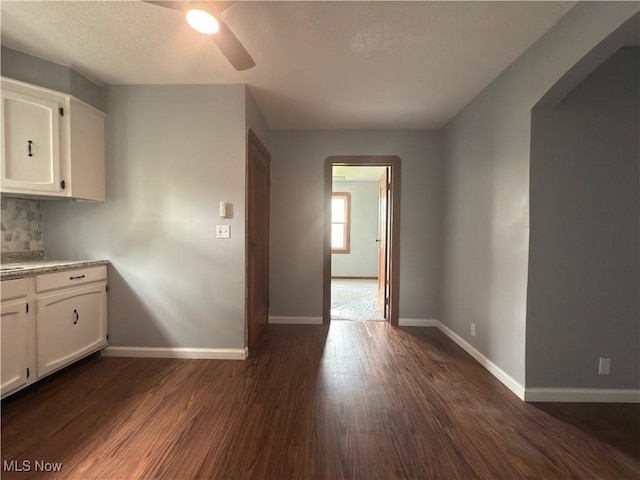 131 Blake St, Elyria, OH 44035 - kitchen with ceiling fan, white cabinetry, arched walkways, and dark wood-style floors