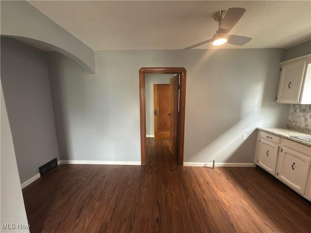 131 Blake St, Elyria, OH 44035 - interior space featuring a ceiling fan, white cabinets, dark wood-type flooring, baseboards, and light countertops