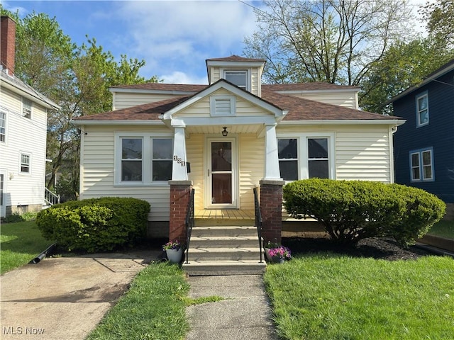 131 Blake St, Elyria, OH 44035 - bungalow-style house featuring covered porch, roof with shingles, and a front yard