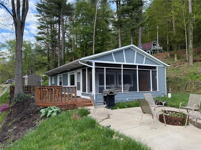 37080 Penrose Ln, Cadiz, OH 43907 - rear view of house featuring a sunroom, a patio area, a deck, and a fire pit