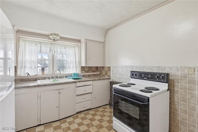 2419 Carpenter Rd, Ashtabula, OH 44004 - kitchen featuring a sink, tile walls, white cabinetry, light countertops, and electric stove