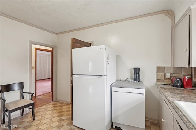 2419 Carpenter Rd, Ashtabula, OH 44004 - kitchen with a sink, freestanding refrigerator, crown molding, light countertops, and tasteful backsplash