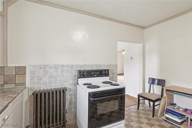 2419 Carpenter Rd, Ashtabula, OH 44004 - kitchen featuring tile walls, radiator, ornamental molding, electric range, and wainscoting