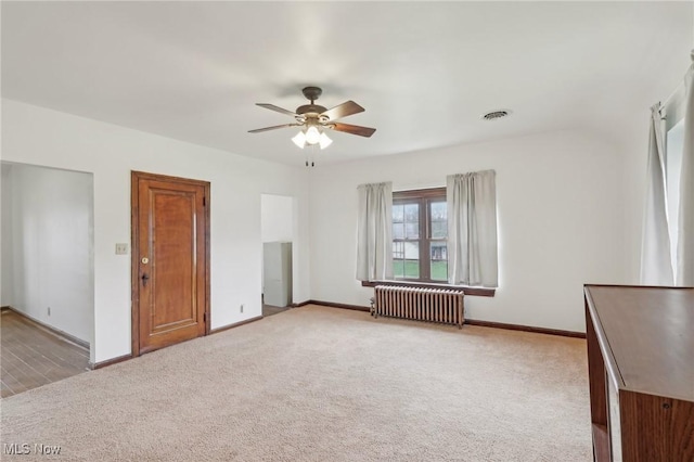 2419 Carpenter Rd, Ashtabula, OH 44004 - spare room featuring baseboards, radiator, ceiling fan, visible vents, and light colored carpet