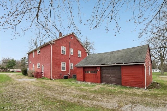 2419 Carpenter Rd, Ashtabula, OH 44004 - rear view of house with a detached garage, a shingled roof, a chimney, and an outbuilding