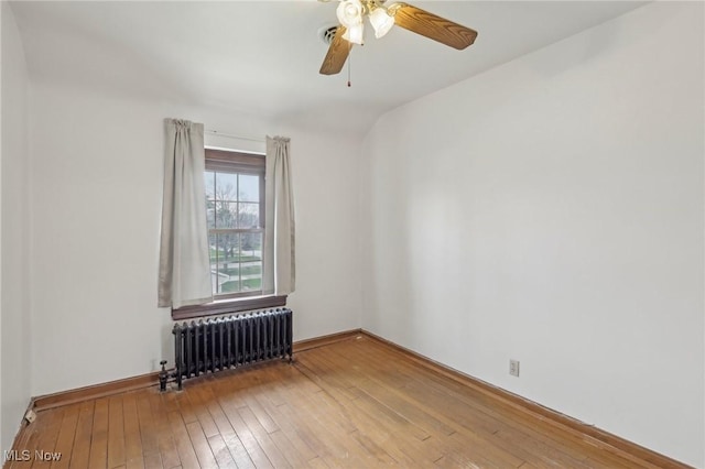 2419 Carpenter Rd, Ashtabula, OH 44004 - spare room featuring baseboards, hardwood / wood-style floors, radiator heating unit, and ceiling fan