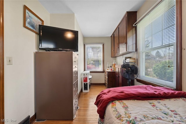 bedroom with light wood-style flooring and baseboards