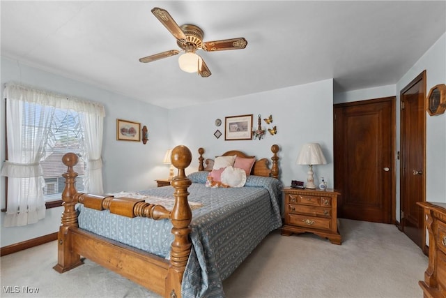 bedroom featuring light carpet, baseboards, and a ceiling fan