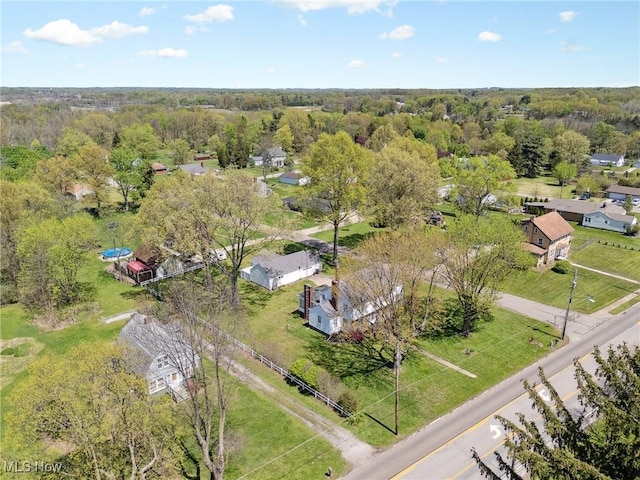 drone / aerial view featuring a residential view and a view of trees