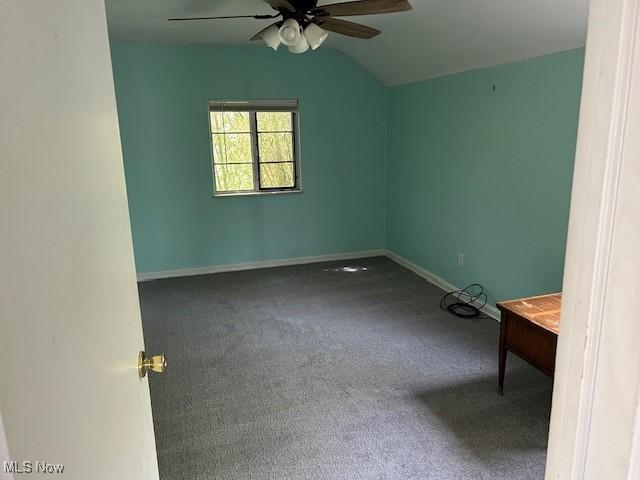unfurnished room featuring lofted ceiling, baseboards, ceiling fan, and carpet