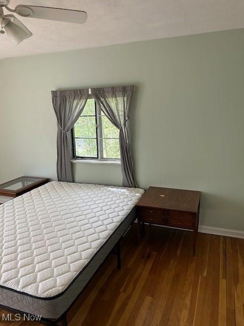 bedroom with ceiling fan, baseboards, and dark wood finished floors