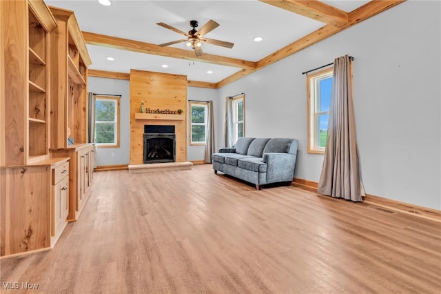 1250 Alamo Rd SE, Carrollton, OH 44615 - living room with a ceiling fan, a fireplace with raised hearth, baseboards, beamed ceiling, and light wood-style floors