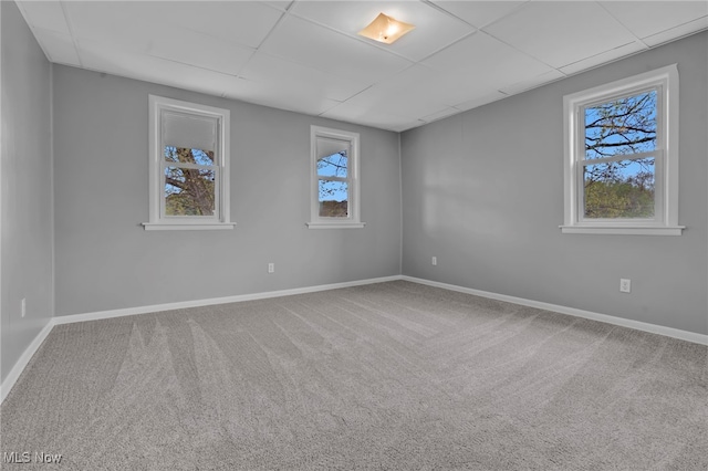 1250 Alamo Rd SE, Carrollton, OH 44615 - empty room featuring carpet flooring, a wealth of natural light, a drop ceiling, and baseboards