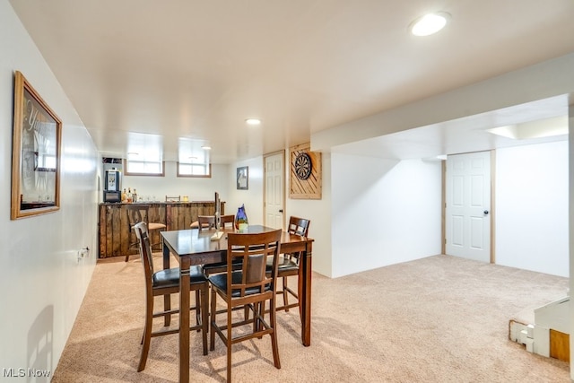 dining space featuring light colored carpet, wet bar, and recessed lighting