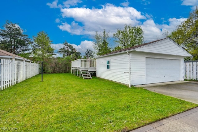 view of yard with fence, a detached garage, stairs, a deck, and an outbuilding
