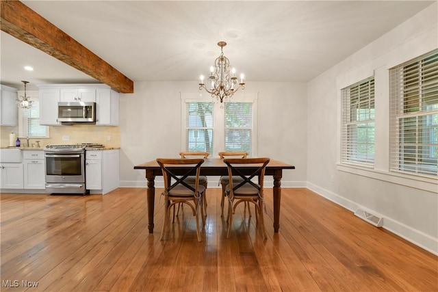 dining space with baseboards, visible vents, a chandelier, and light wood-type flooring