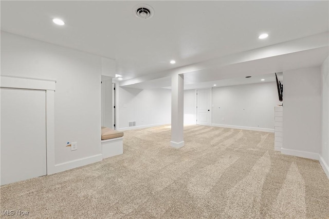 finished below grade area featuring baseboards, recessed lighting, light carpet, and visible vents