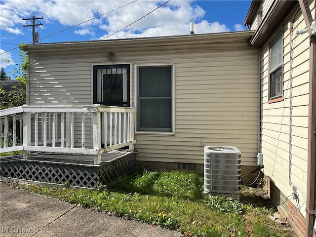 doorway to property with central AC unit, a deck, and crawl space