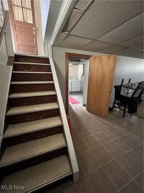stairs with tile patterned flooring and independent washer and dryer
